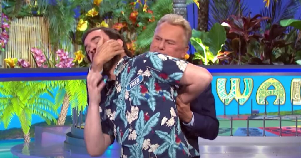 "Wheel of Fortune" host Pat Sajak puts a contestant in a hammerlock.